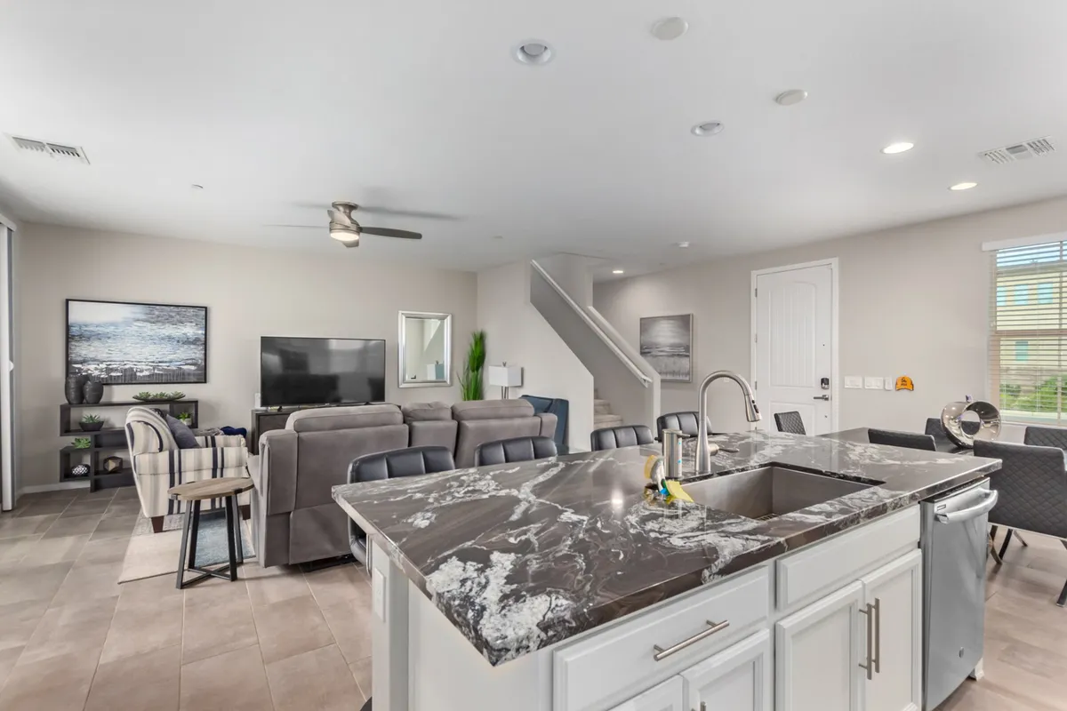 An open-concept kitchen and living area with a focal kitchen island that encourages both cooking and socializing. The scene captures a welcoming space set up for memorable family meals, with comfortable seating and thoughtful decor.